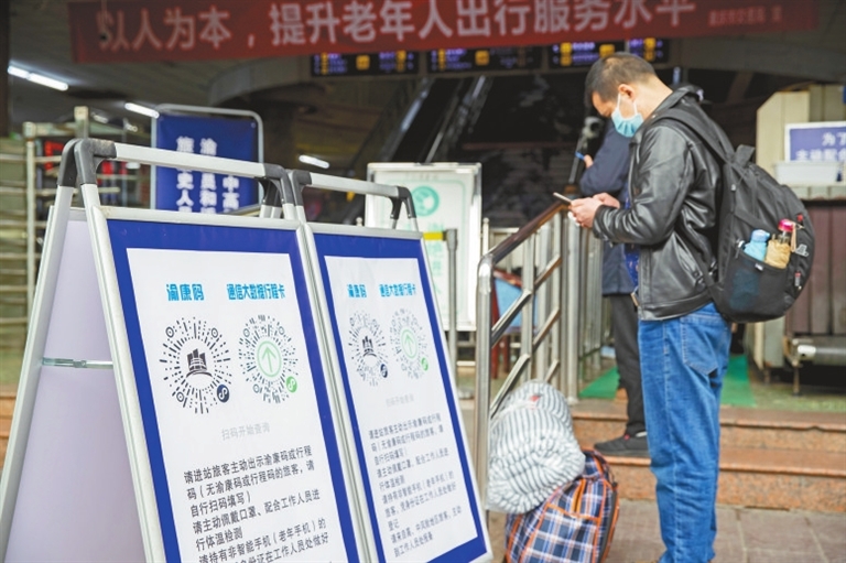 重庆汽车站,旅客在进站口前扫描出示渝康码.