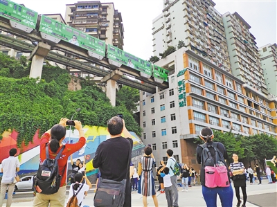 游客在李子坝观景平台拍摄"轻轨穿楼". 记者 姚延洋 摄