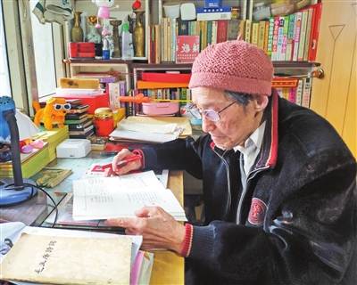 张继楼正在看《儿歌颂筷》全国征稿作品集. 记者 姚延洋 摄